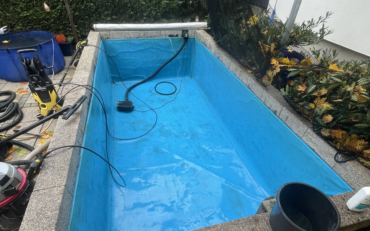 Dasselbe Koibecken aus demselben Blickwinkel nach der Komplettreinigung — sauber ausgespülte blaue Folie